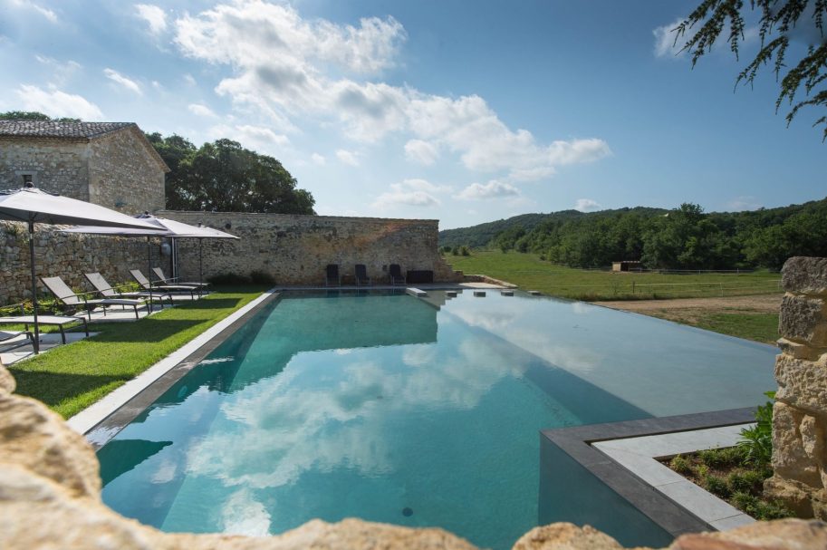 Piscine miroir privée face aux collines boisées d'un domaine de luxe en pierres – retreat Access Flow