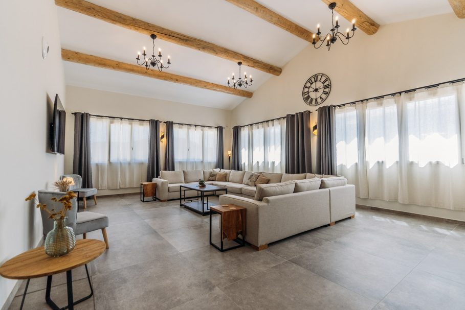 Vaste salon lumineux avec poutres en chêne et canapés en U pour retraite de groupe – Access Flow