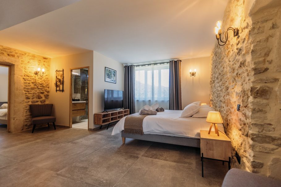 Suite avec mur en pierre dorée, éclairage tamisé et literie hôtel 5 étoiles – Access Flow Retreats